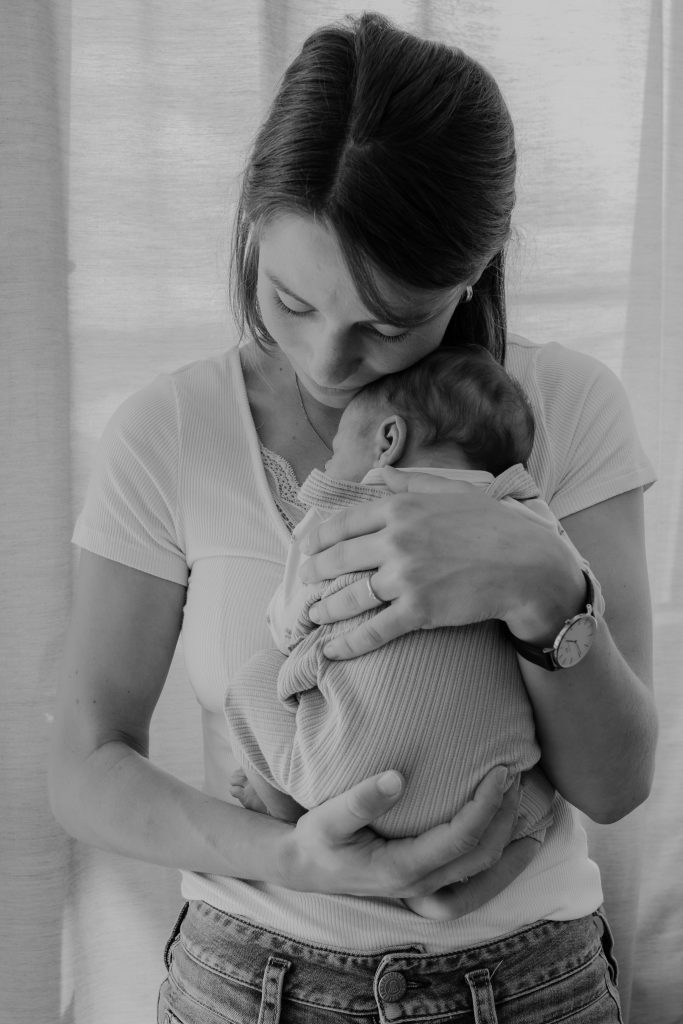 Mutter kuschelt mit ihrem neugeborenen Baby
